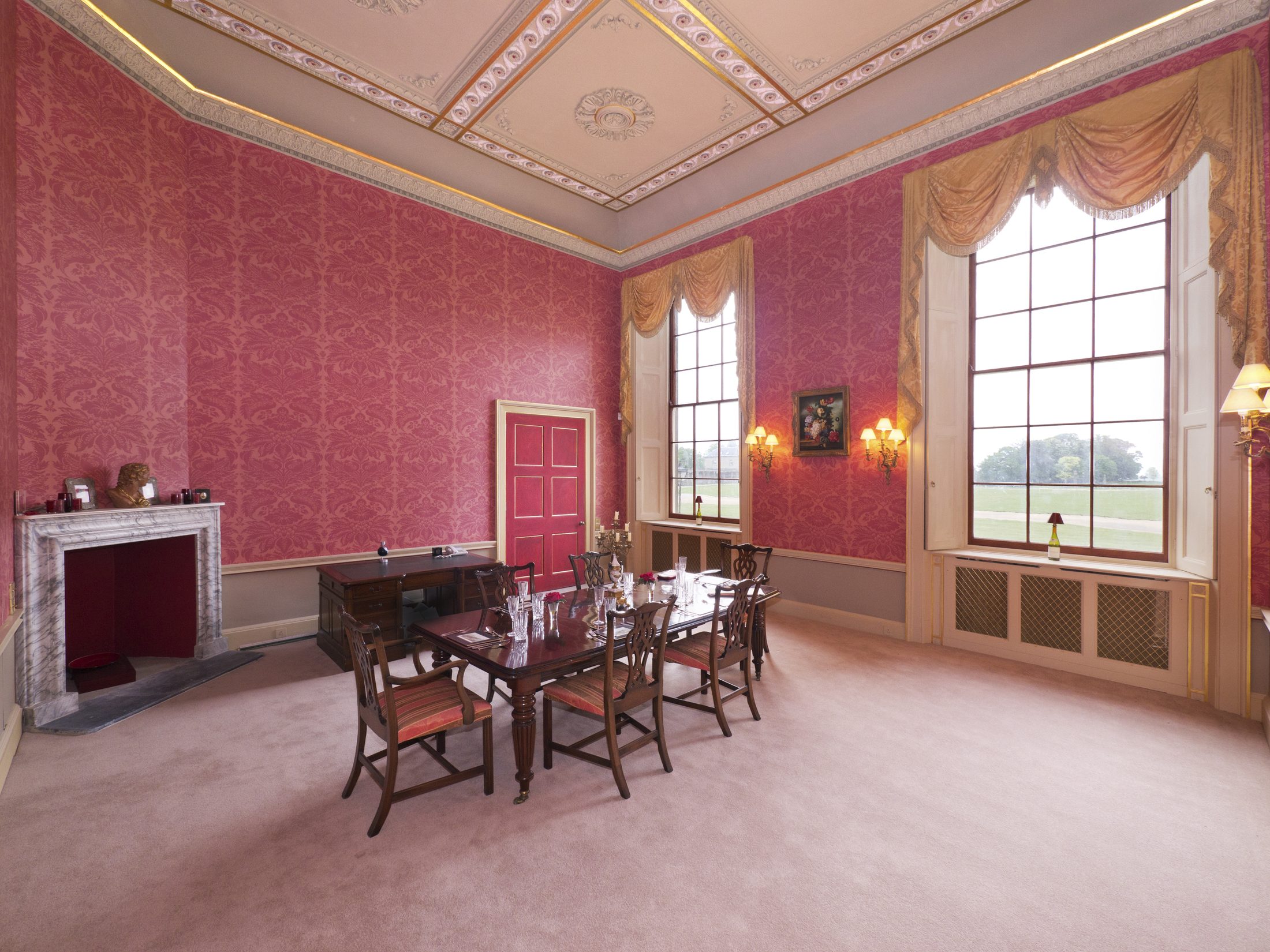 The Dining Room, set for dinner, with damask walls and a coffered, gilded ceiling